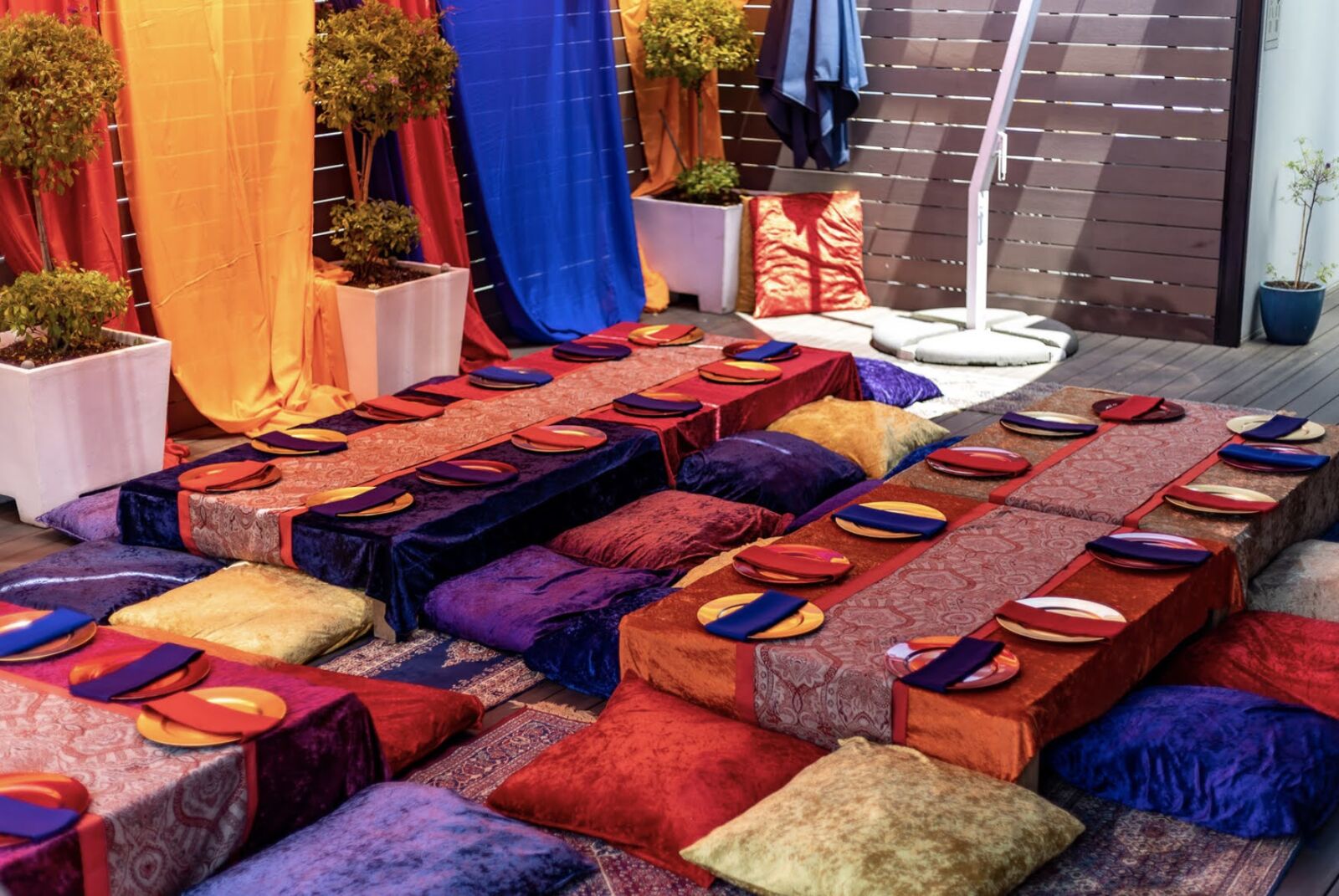 Low tables with cushions and colourful drapes set up for a Moroccan-style party